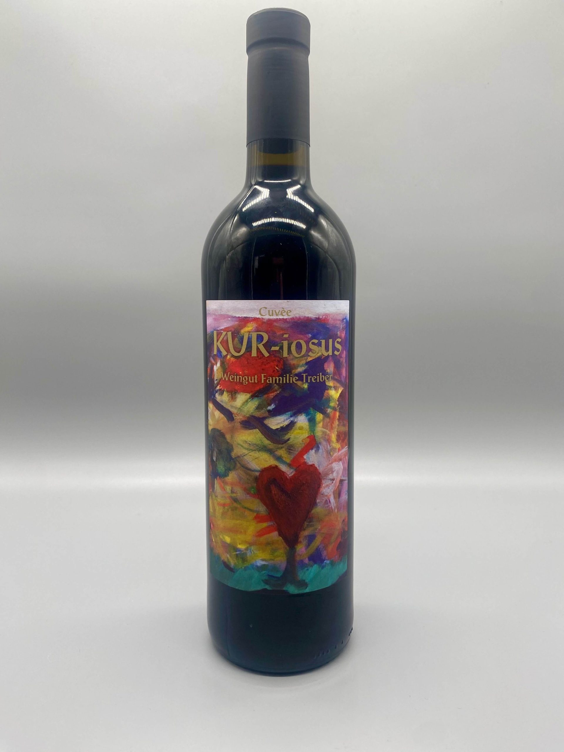 Flasche Rotwein Cuvée "KUR-iosus" von Weingut Familie Treiber mit buntem, abstraktem Herz auf dem Etikett.