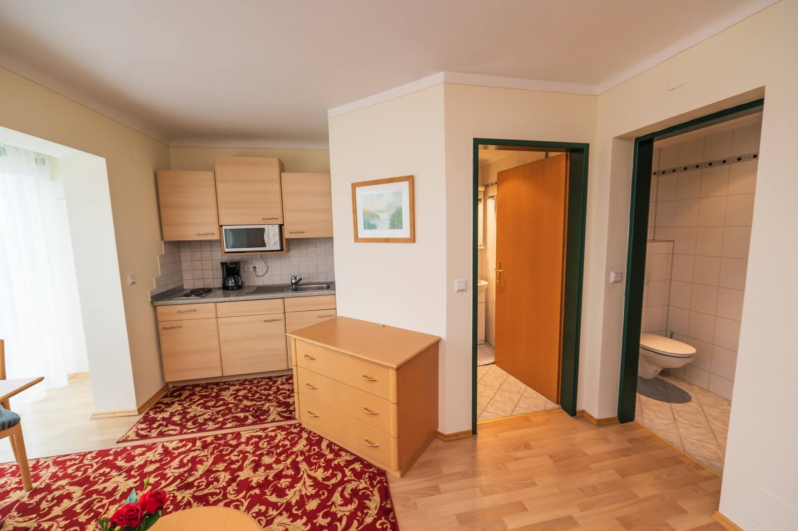 Wohnbereich eines Apartments mit komfortabler Sitzecke, Esstisch und angrenzender offener Küche im Gasthaus Treiber.