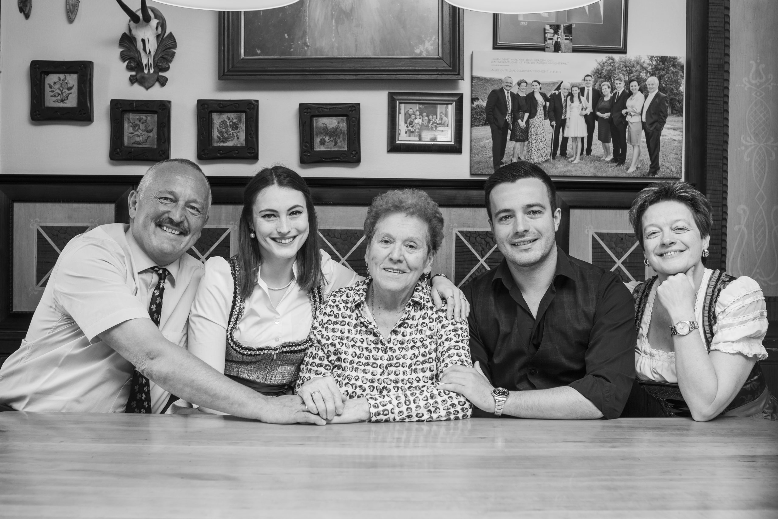 Schwarz-Weiß-Foto einer fröhlichen Familie mit traditioneller österreichischer Tracht im Gasthaus Treiber.
